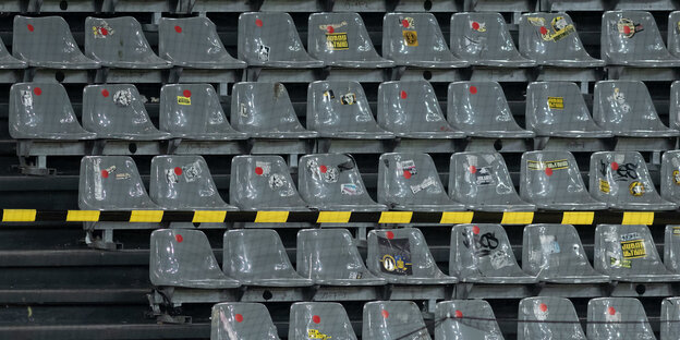 Ein paar Menschen sitzen auf der ansonsten leeren Tribünde des Dortmunder Stadions
