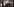 Menschen halten Plakate mit Dem Portrait des ivoirianischen Präsidenten Ouattara