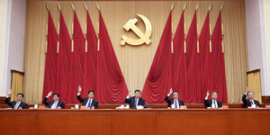 Chinesische Führungskräfte sitzen auf einem Podium beim 19 Treffen des Zentralkommittees