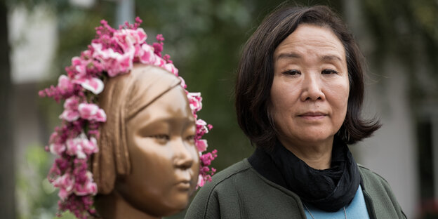 Vorstandvositzende des Korea-Verbands Berlin Nataly Jung-Hwa Han steht neben der Statue der Trostfrauen in Berlin Moabit