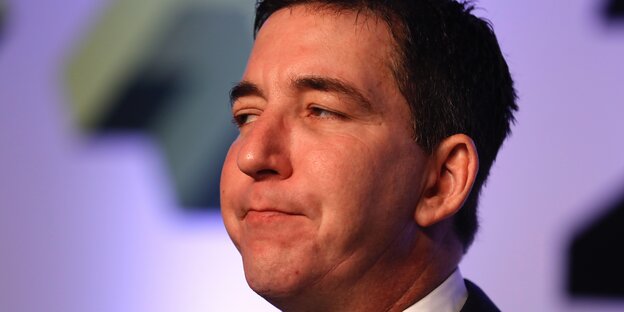 Seitlich fotografierter Glenn Greenwald, der die Lippen aufeinander presst.