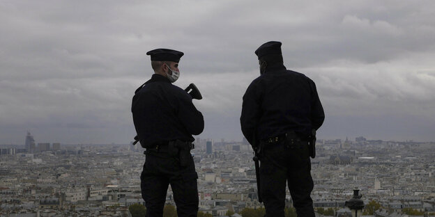 Zwei Polizisten blicken auf die Stadt Paris