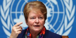 Gro Harlem Brundtland vor WHO-Logo