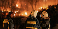 Feuerwehrleute stehen vor den Bränden im Flüchtlingslager auf Samos
