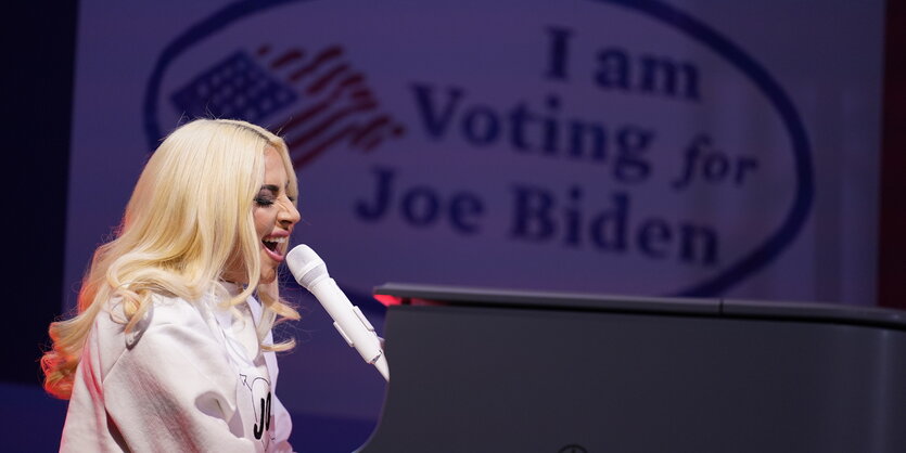 Lady Gaga singt am Klavier, im Hintergrund ein Bild mit der Aufschrift "I am Voting for Joe Biden"