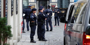 Polizistinnen stehen bei Tageslicht in der Wiener Innenstadt und gestikulieren.