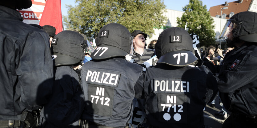 Eine Kette von Bereitschaftspolizisten blockiert Demonstranten.