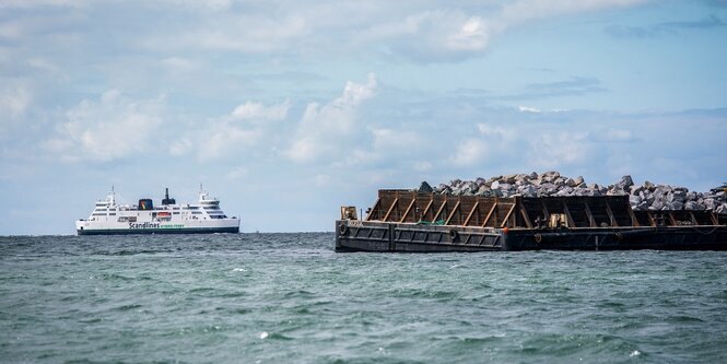 Ein Fährschiff und eine Baustelle im Meer