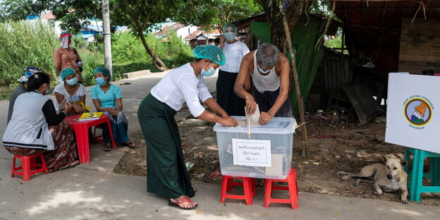 Vor einem Wahllokal in Yangon gibt ein Mann seine Stimme ab