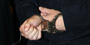 Die Hände des Angeklagten mit Handschellen gefesselt