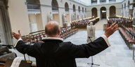 Ein Priester steht mit erhobenen Armen in der Frauenkirche von Kopenhagen