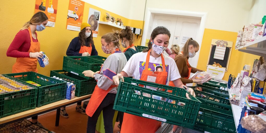 Mitarbeiterinnen der Bremerhavener Tafel bereiten Körbe mit Lebensmitteln für die Ausgabe vor