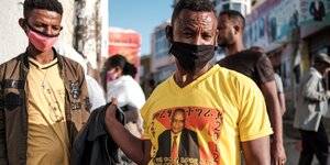 Männer stehen auf der Straße, ein mann trägt ein T-shirt mit dem Konterfei eines Politikers aus der äthiopischen Provinz Tigray