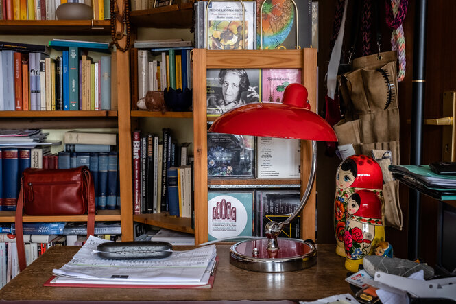 Eine Schreibtischlampe vor einem Bücherregal