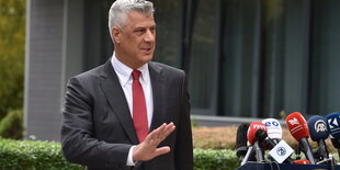 Präsident Hashim Thaçi steht vor Mikrofonen