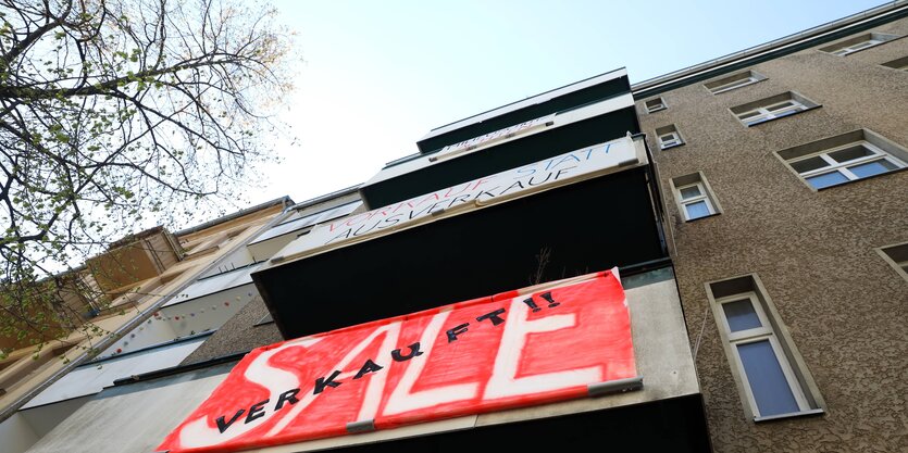 Protestbanner mit der Schrift "Sale" an einer Hausfassade