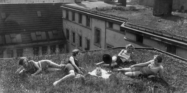 vier junge Frauen liegen auf einem Dach in Berlin und hören Grammophon