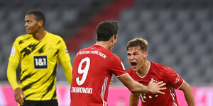 zwei Bayern-Spieler jubeln, ein Dortmunder enttäuscht im Hintergrund