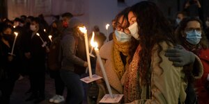 Zwei Mädchen halten zwei Kerzen vor einer Masse bei der trauerfeier in Wien