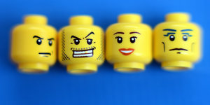 Die Köpfe von Lego-Männchen mit verschiedenen Gesichtern