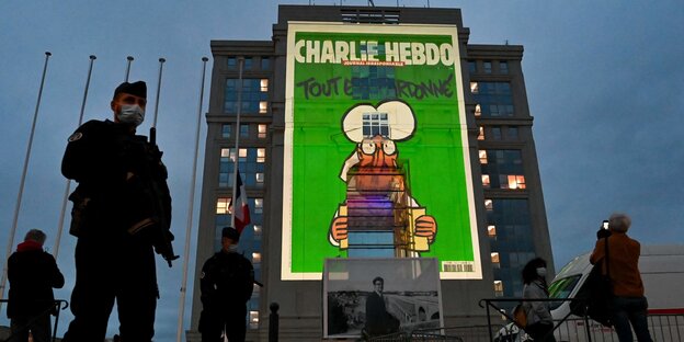 Foto von Charlie Hebdo auf Hochhaus mit Polizei