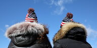 Zwei Trump-Fans mit gleichen Mänteln und Pudelmützen in den Farben der amerikanischen Fahne