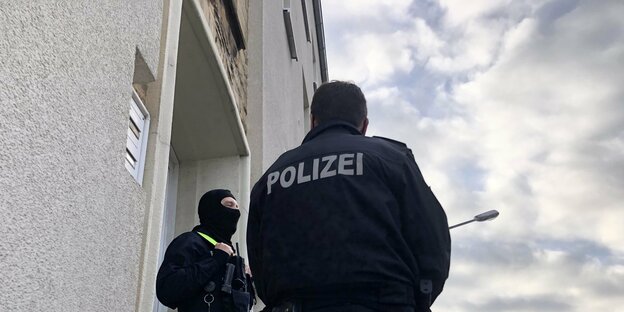 Zwei Polizisten stehen vor einem Wohnhaus in Osnabrück