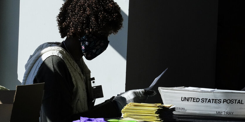 Eine Wahlhelferin wertet die Wahlzettel aus