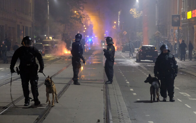 Hundeführer der Polizei sperren bei Ausschreitungen im Stadtteil Connewitz eine Straße.