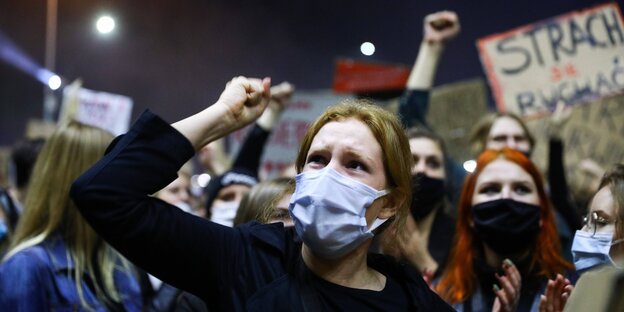 Frauen protestieren und heben ihre Fäuste