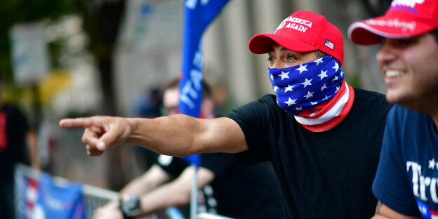 Trump-Anhänger in Philadelphia mit roten Trump-Mützen rufen Biden-Fans etwas engegen