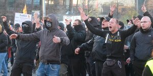 Männer schreien und breiten bei Corona-Protest in Leipzig die Arme aus