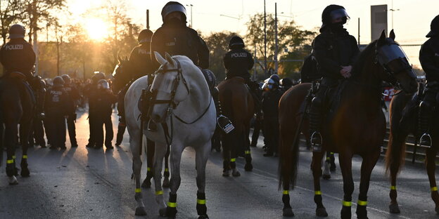 Polizisten in Schutzmontur auf Pferden