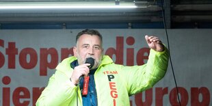 Pegida-Gründer Lutz Bachmann in grüner Jacke auf einer Bühne