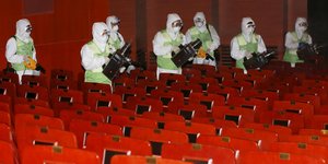 Arbeiter in Schutzanzügen desinfizieren den Zuschauerraum im Kulturzentrum Seoul
