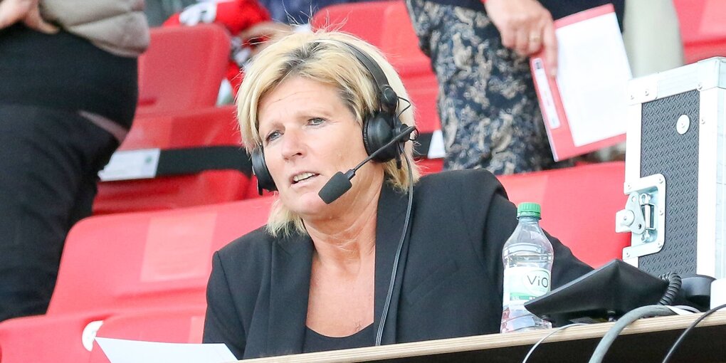 Claudia Neumann mit Headset auf der Pressetribüne im Stadion