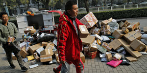 China, Peking: Zusteller sortieren Pakete, die sich an einem Abholpunkt in der Nähe eines Wohnhauses stapeln. Chinas Online-Riese Alibaba hat während der größten Rabattschlacht der Welt einen Verkaufsrekord erzielt.