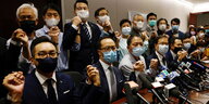 Abgeordnete des Hongkonger Parlaments halten sich bei an den Händen und geben eine Pressekonferenz