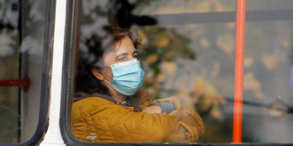 Eine Frau mit Maske in einem Bus