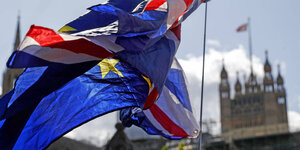 Ineinander verschlungene Europäische und Britische Flaggen vor dem House of Parliament in London