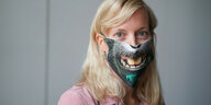 Auf dem Foto sieht man eine blonde Frau mit Mund-Nasen-Maske