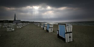 Strandkörbe am Strand in der Abenddämmerung.