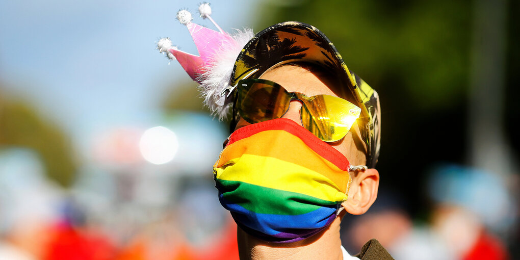 Ein Mann mit Gesichtsmaske in Regenbogenfarben