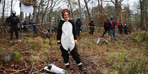 Carola Rackete im Dannenröder Forst - hinter ihr Baumhäuser und Polizisten