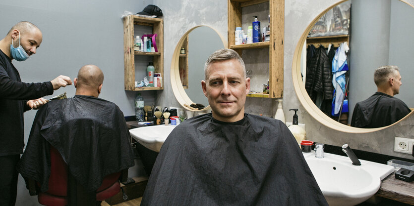 Marcus Staiger, ehemaliger Raplabel-Chef und aktueller Kampfsportler, Industriekletterer und linker Aktivist - fotografiert beim Friseur am Kotti, mit einem Friseurumhang