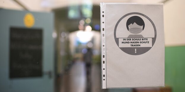 In einer Grundschule in Kreuzberg wird mit einem Schild mit der Aufschrift „In der Schule bitte Mund-Nasen-Schutz tragen“ auf die Hygieneregeln hingewiesen