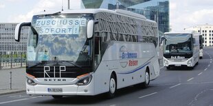 Ein Reisebus mit der Aufschrift "Zuschüsse sofort!" und "RIP"