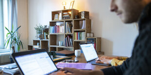 Michael Baumgartner (vorne) und Svenja Schneider arbeiten während der Corona-Pandemie im Home Office an ihren Laptops.