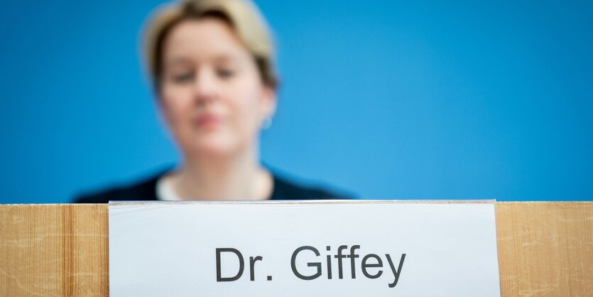 Eine Frau sitzt bei einer Pressekonferenz