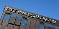 Braunes Gebäude mit dem Schriftzug "Freie Universität Berlin" im Anschnitt mit blauen Himmel im Hintergrund